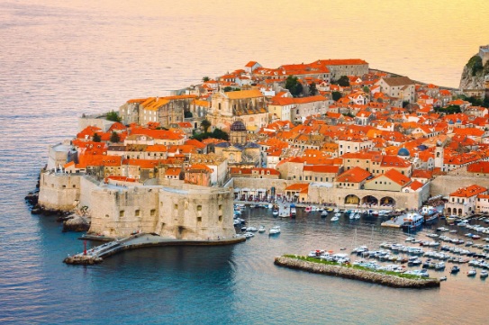 Luxury yacht cruising near Dubrovnik, Croatia, with ancient city walls, clear blue Adriatic waters, and a scenic coastal panorama