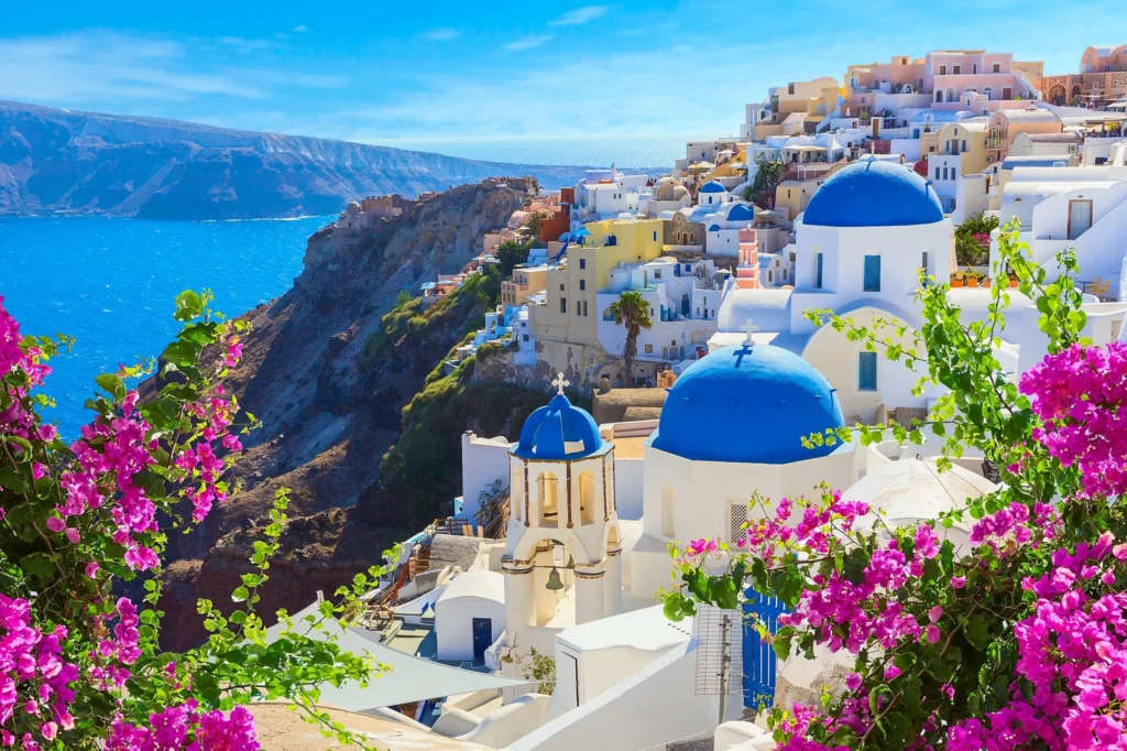Luxury yacht sailing near Santorini, Greece, with iconic white buildings, deep blue sea, and dramatic volcanic cliffs