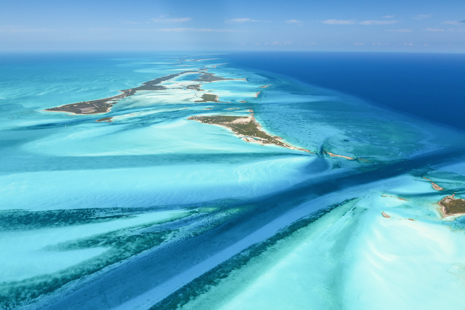 Luxury yacht cruising near Exuma Cays in the Bahamas, with sparkling turquoise waters, scattered idyllic islands, and breathtaking Caribbean views.
