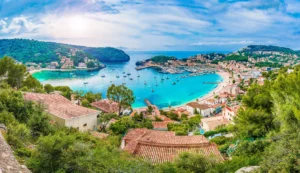 Luxury yacht anchored in a serene bay in Mallorca, Spain, with turquoise waters, golden sandy beaches, and lush green hills in the background