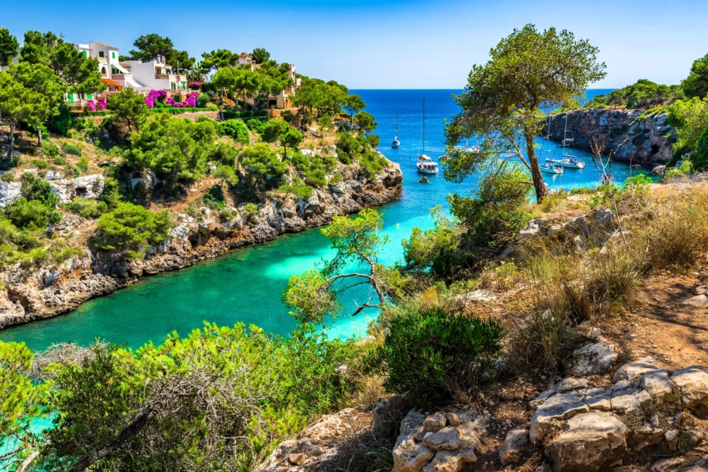 Luxury yacht sailing in the Balearic Sea, with deep blue waters, scattered Mediterranean islands, and a clear sky