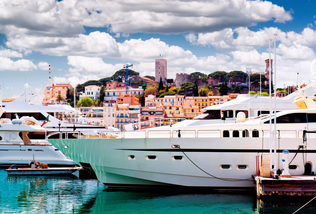 Luxury yacht anchored near Cannes, France, showcasing the glamorous French Riviera marina, iconic Croisette, and sparkling Mediterranean waters