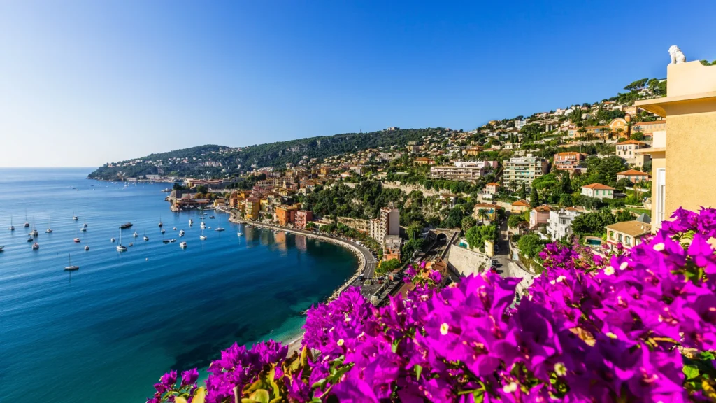 Luxury yacht cruising the sparkling waters of the French Riviera, featuring iconic coastal views, glamorous marinas, and a sunlit Mediterranean backdrop