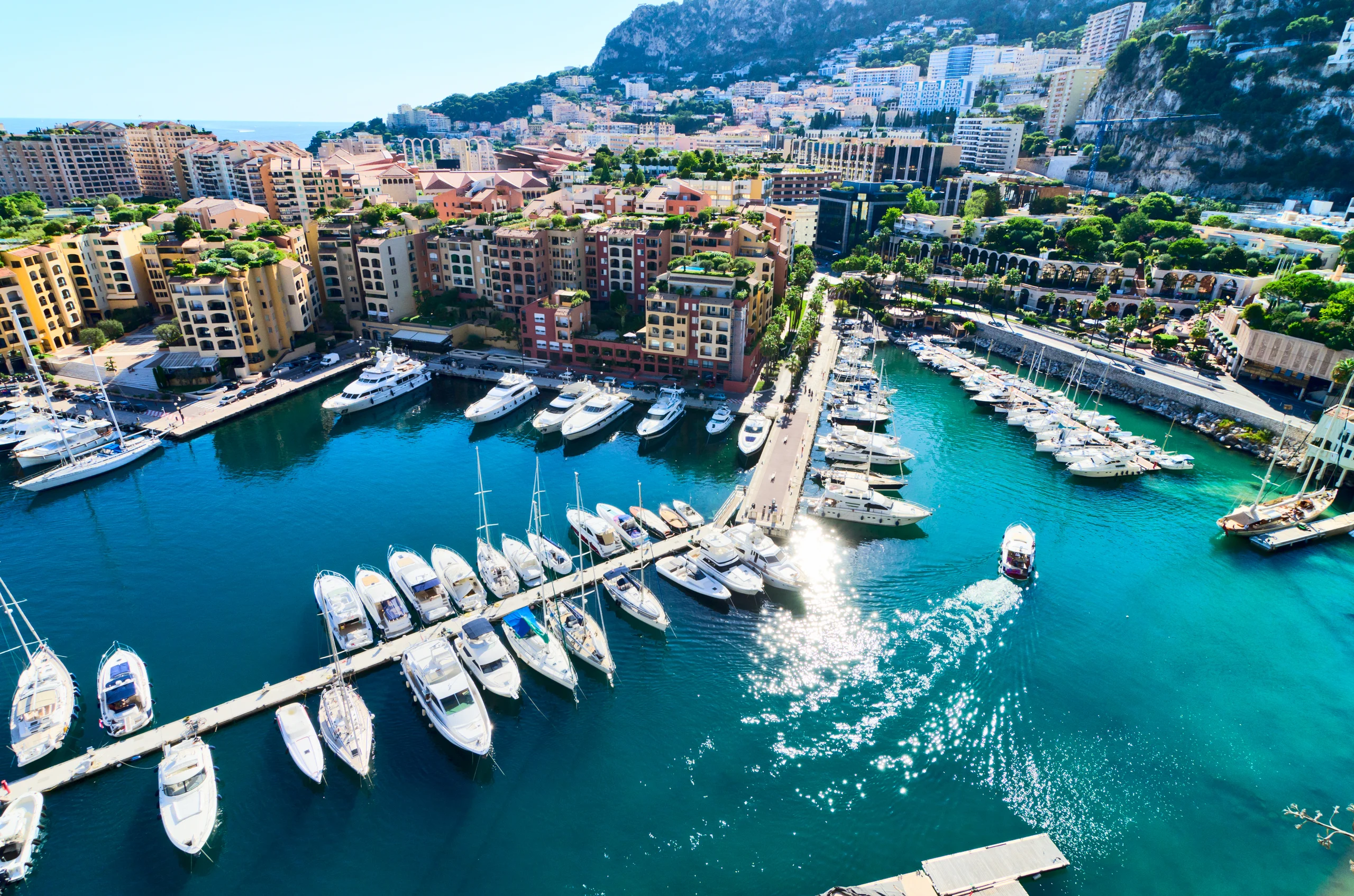 Luxury yacht docked at Monaco Marina, with elegant yachts and the stunning Mediterranean backdrop of Monaco's iconic skyline