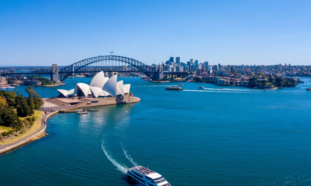 Luxury yacht anchored off the coast of Australia with the Great Barrier Reef, golden beaches, and turquoise waters in view.