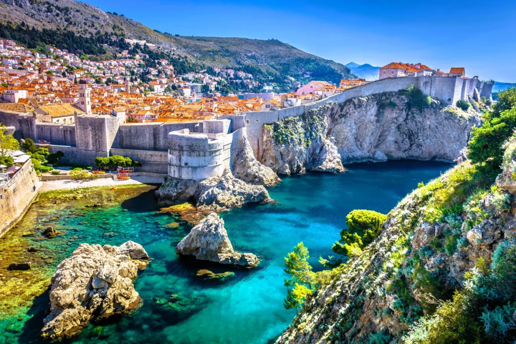 Luxury yacht cruising along Croatia's stunning Adriatic coast, with crystal-clear waters, ancient coastal towns, and a vibrant marina backdrop