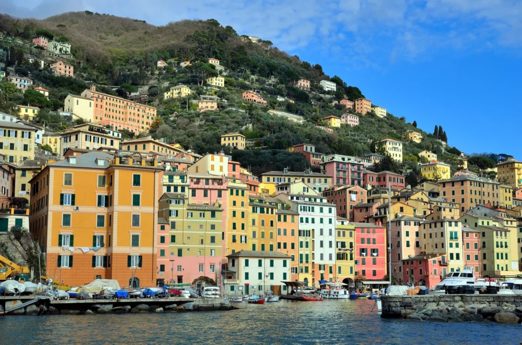 Luxury yacht cruising near Genoa, Italian Riviera, with historic harbor views, colorful coastal architecture, and sparkling Mediterranean waters.
