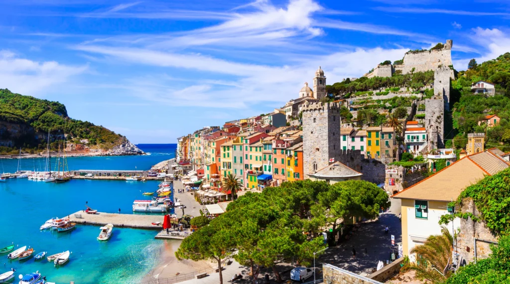 Luxury yacht anchored near Elba, Italy, with turquoise waters, lush green hills, and charming coastal villages along the Italian Riviera.