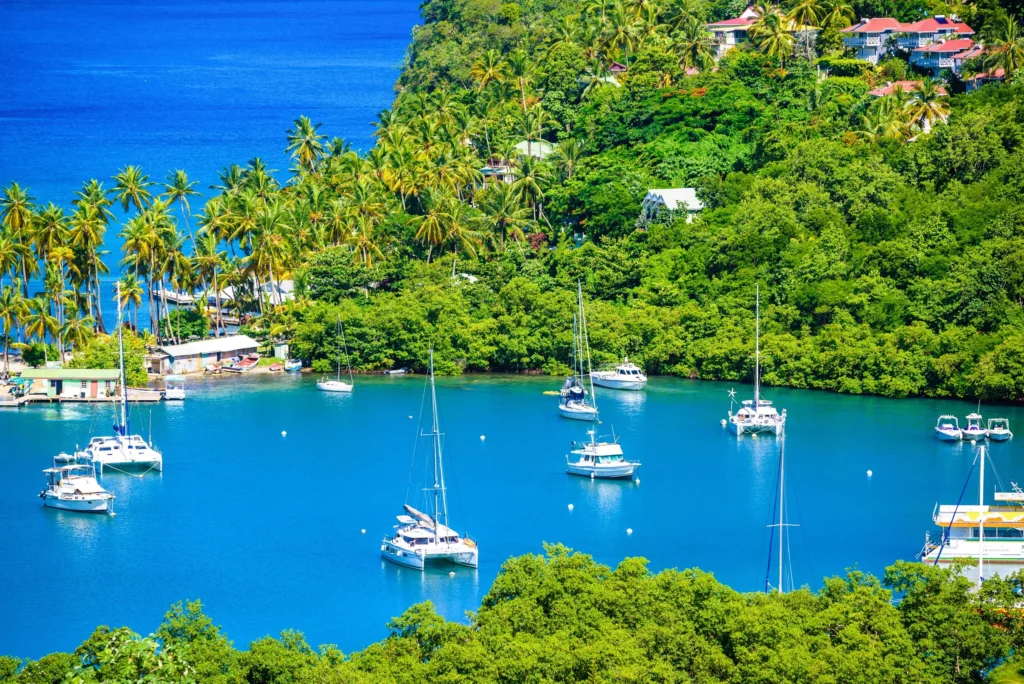 Luxury yacht sailing near St. Lucia, Caribbean, with the iconic Piton mountains, lush green landscapes, and sparkling turquoise waters in view.