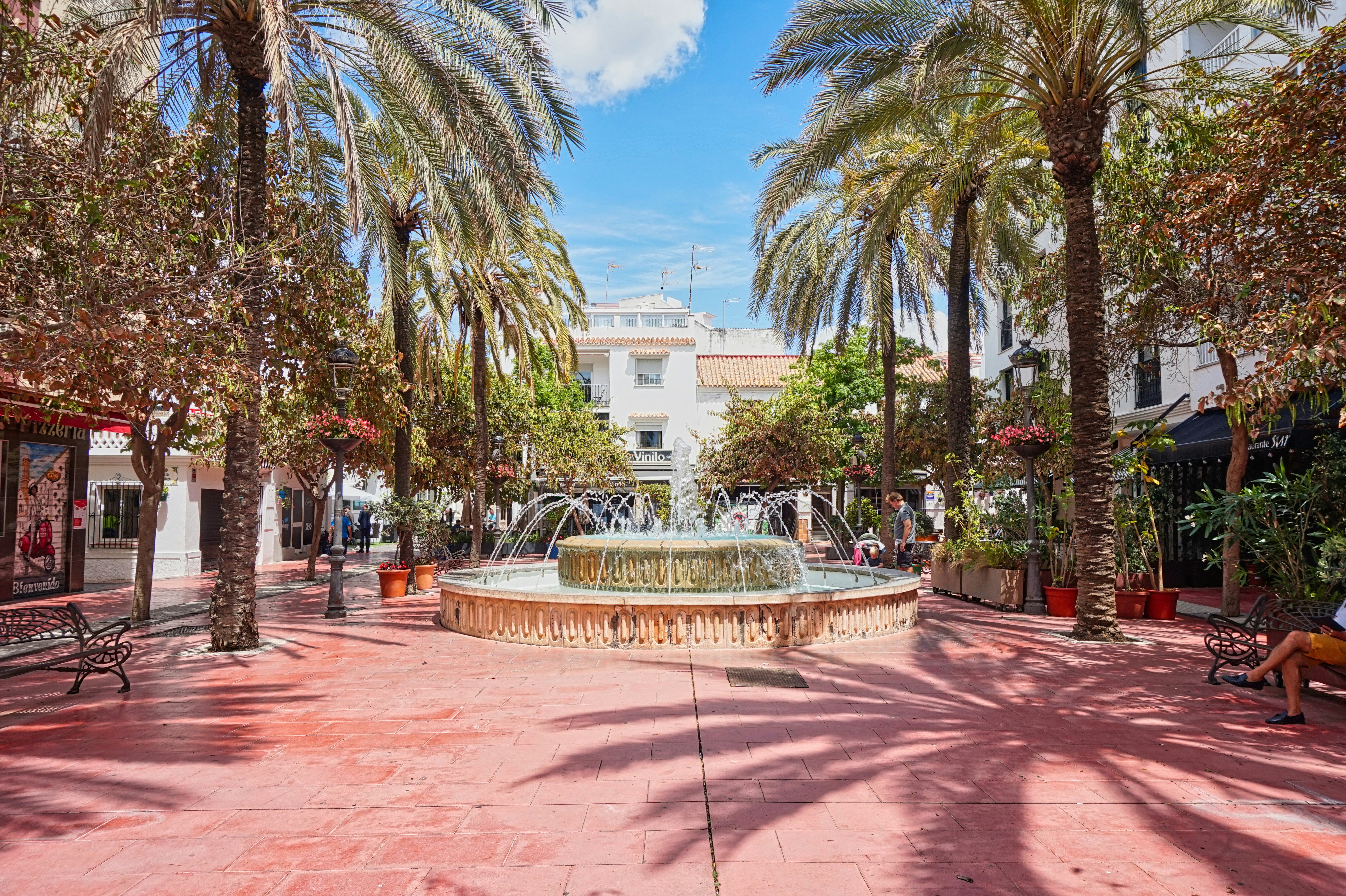 Luxury yacht cruising near Estepona, Spain, with clear Mediterranean waters, a vibrant marina, and picturesque coastal scenery