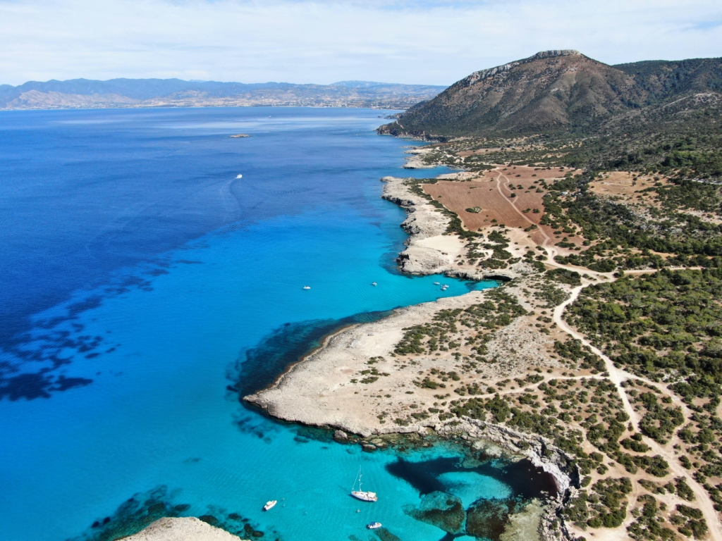 Luxury yacht cruising near Paphos, Cyprus, with sparkling Mediterranean waters, ancient ruins, and scenic coastal views.