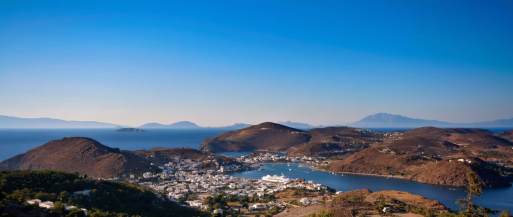 Luxury yacht cruising near Patmos in the Dodecanese Islands, Greece, with pristine blue waters, rugged coastlines, and ancient ruins.