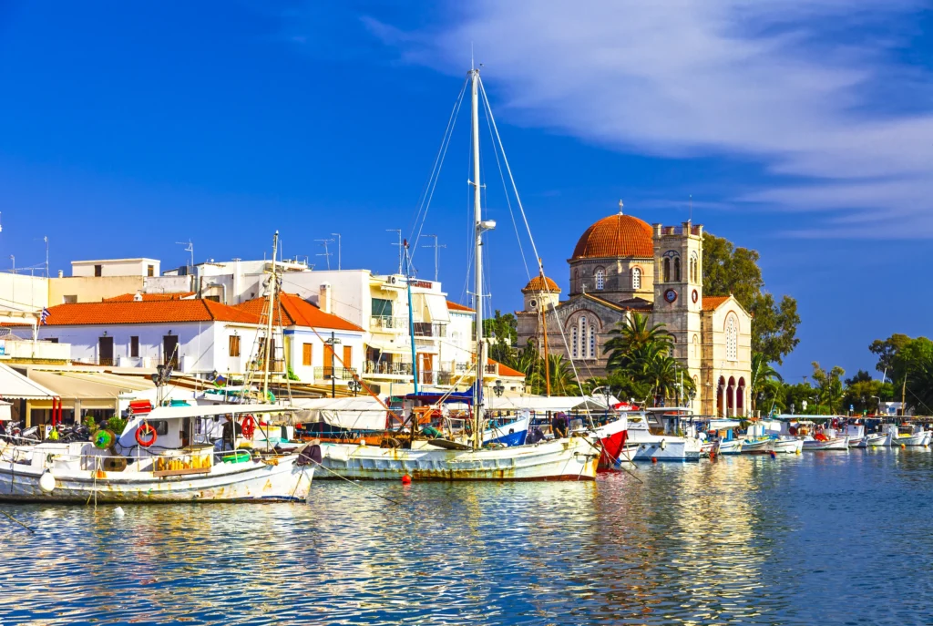 Luxury yacht cruising near Aegina in the Saronic Gulf, Greece, with scenic blue waters, ancient temples, and picturesque coastal views