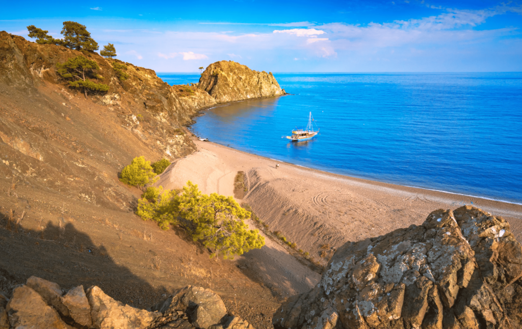 Luxury yacht cruising near Antalya, Turkey, with turquoise Mediterranean waters, ancient ruins, and dramatic coastal scenery.
