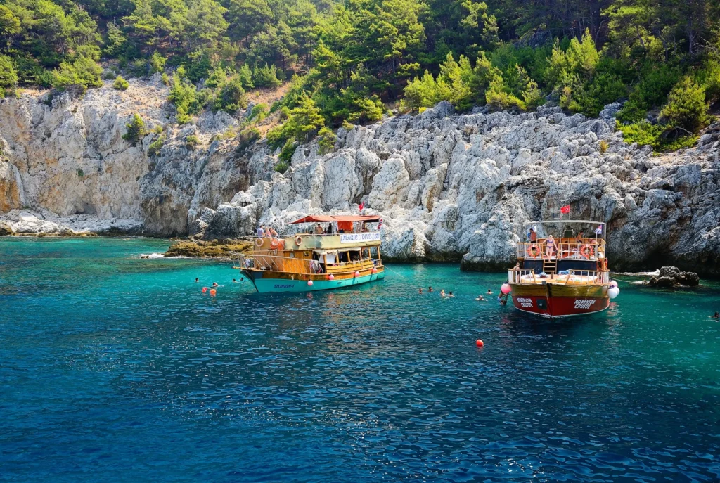Luxury yacht cruising near Antalya, Turkey, with turquoise Mediterranean waters, ancient ruins, and dramatic coastal scenery.
