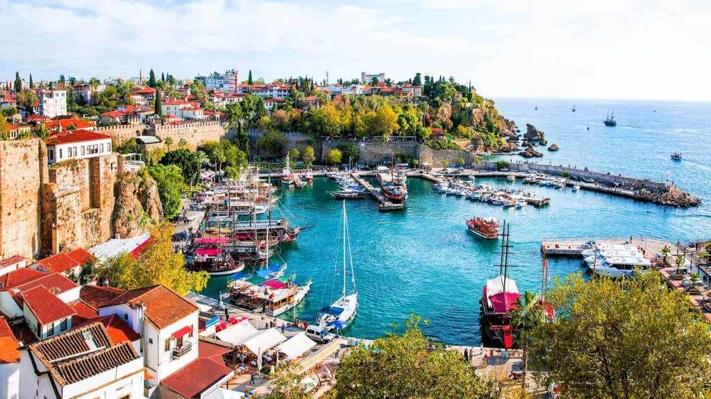 Luxury yacht cruising near Antalya, Turkey, with turquoise Mediterranean waters, ancient ruins, and dramatic coastal scenery.
