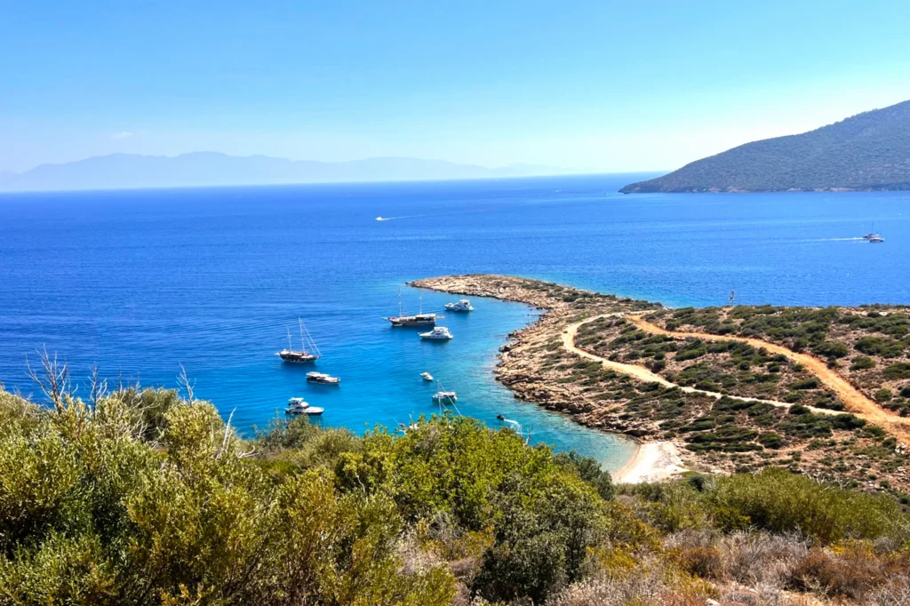 Luxury yacht cruising near Bodrum, Turkey, with pristine turquoise waters, scenic coastal views, and a vibrant marina backdrop.