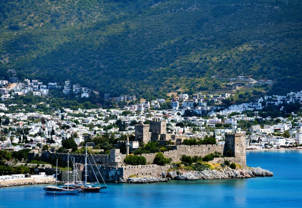 Luxury yacht cruising near Bodrum, Turkey, with pristine turquoise waters, scenic coastal views, and a vibrant marina backdrop.