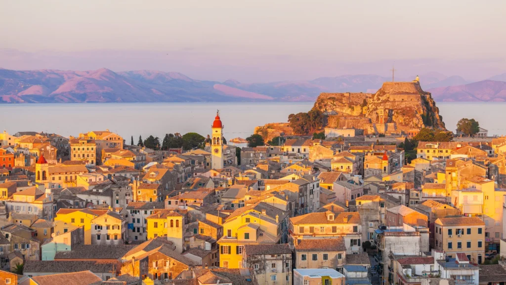 Luxury yacht cruising near Corfu with clear Ionian Sea waters, lush greenery, and picturesque coastal scenery in Greece.