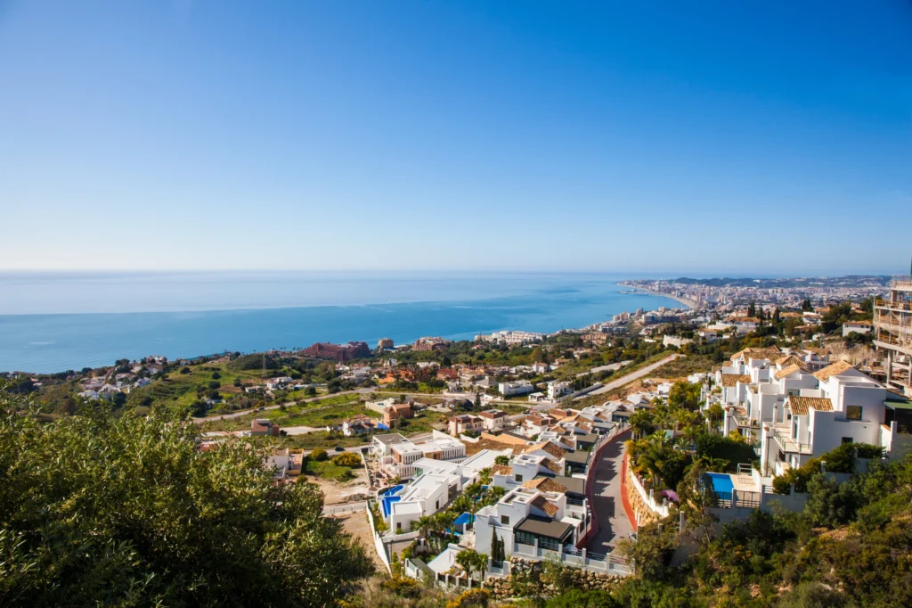 Luxury yacht cruising near Fuengirola, Spain, with crystal-clear Mediterranean waters, vibrant marina, and scenic coastal views