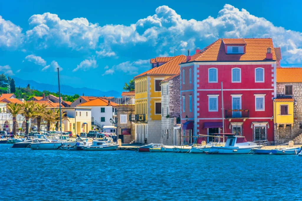 Luxury yacht cruising near Hvar, Croatia, with sparkling Adriatic waters, charming coastal views, and a vibrant port atmosphere.