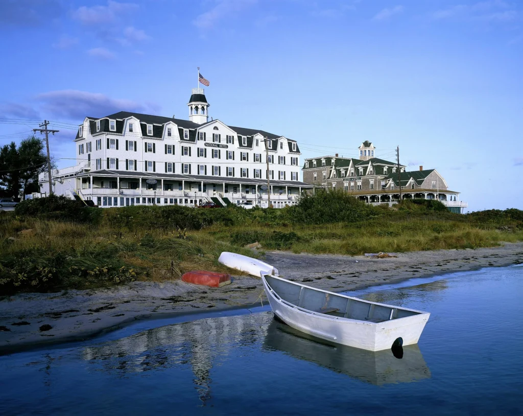 Luxury yacht anchored near Block Island’s Mohegan Bluffs, Rhode Island, with dramatic cliffs, turquoise waters, and a pristine beach in the background