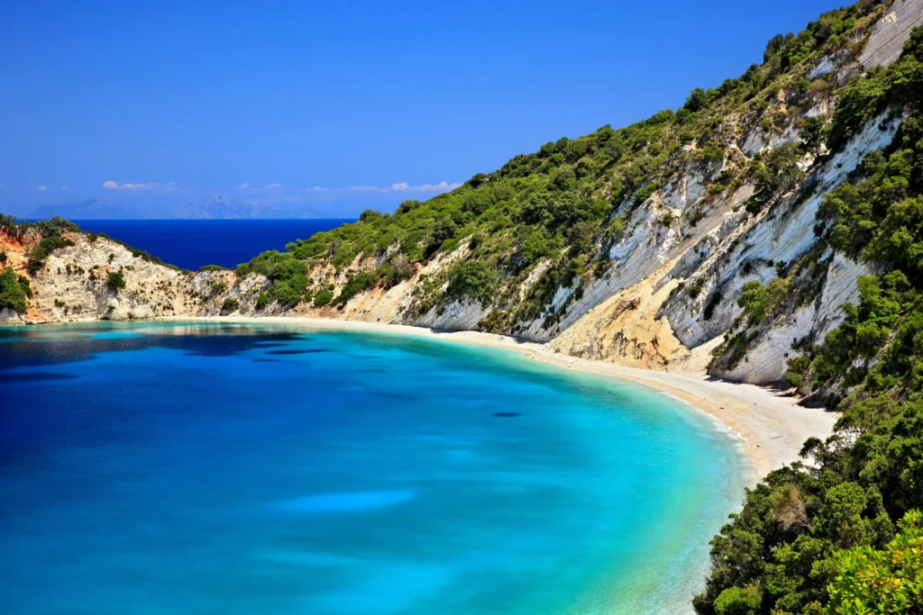 Luxury yacht cruising near Ithaca, Greece, with pristine Ionian Sea waters, rugged coastlines, and lush island scenery.