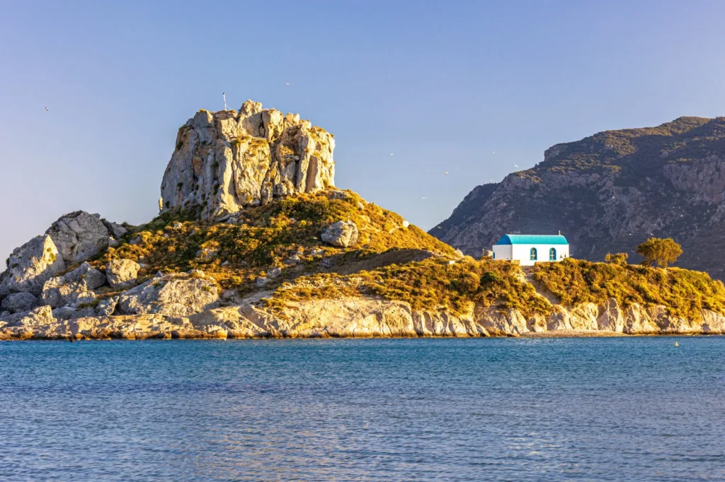 Luxury yacht cruising near Kos in the Dodecanese Islands, Greece, with azure waters, ancient ruins, and a scenic coastline.