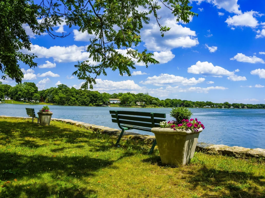 Luxury yacht cruising through Long Island Sound, with calm blue waters, lush green shores, and sailboats in the background