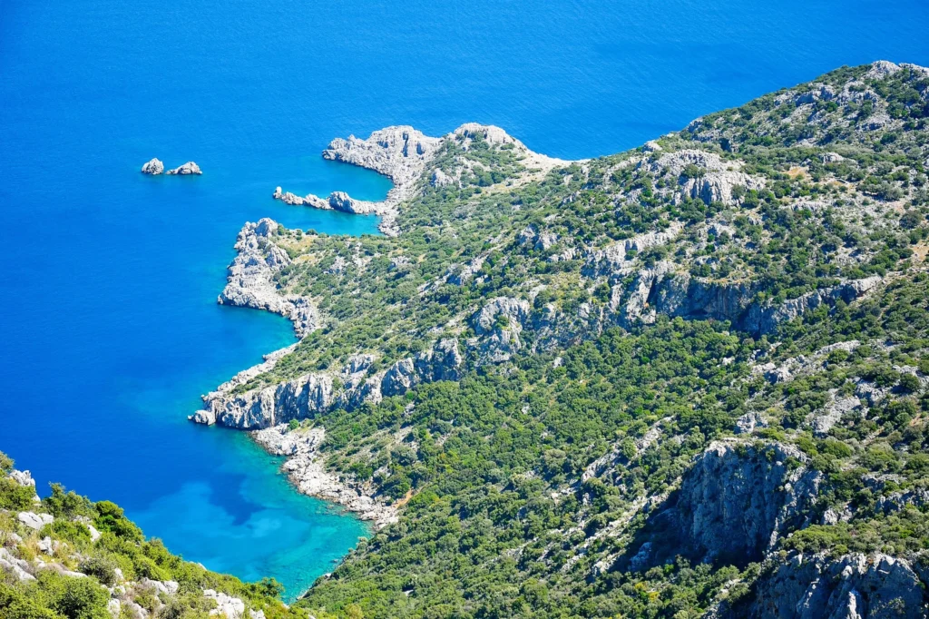 Luxury yacht cruising near Marmaris, Turkey, with sparkling turquoise waters, rugged coastline, and a vibrant marina.