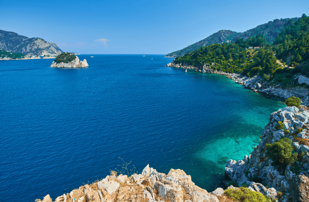 Luxury yacht cruising near Marmaris, Turkey, with sparkling turquoise waters, rugged coastline, and a vibrant marina.