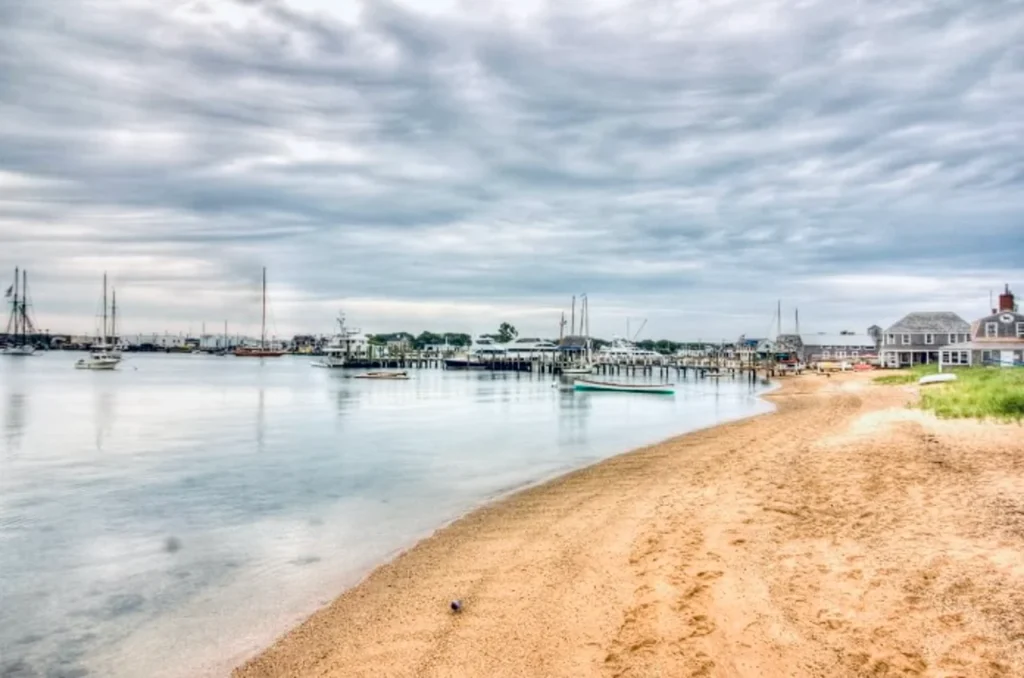 Luxury yacht anchored in Martha’s Vineyard Harbor, Massachusetts, with classic sailboats, a charming New England coastline, and vibrant waterfront activity