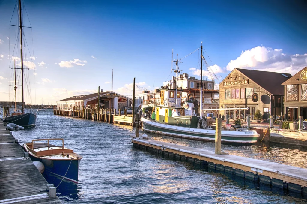 Luxury yachts anchored in Newport Harbor, Rhode Island, with historic sailboats, the iconic Newport coastline, and Gilded Age mansions in the background