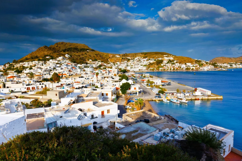 Luxury yacht cruising near Patmos in the Dodecanese Islands, Greece, with pristine blue waters, rugged coastlines, and ancient ruins.
