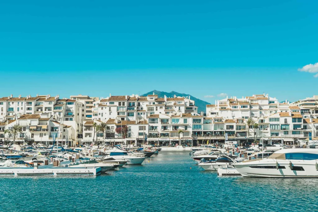 Luxury yacht docked in Puerto Banús, Spain, with vibrant marina views, crystal-clear Mediterranean waters, and upscale coastal scenery