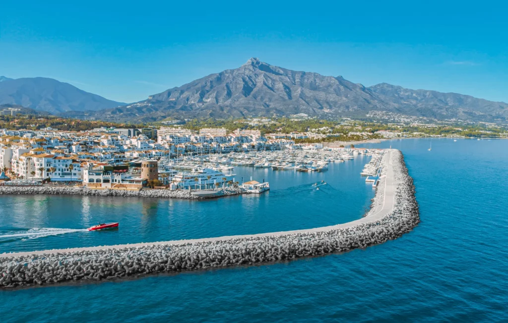 Luxury yacht docked in Puerto Banús, Spain, with vibrant marina views, crystal-clear Mediterranean waters, and upscale coastal scenery
