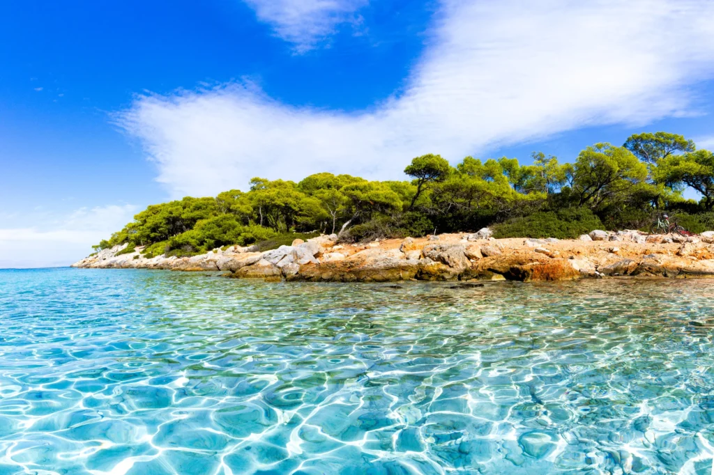 Luxury yacht cruising in the Saronic Gulf, Greece, with crystal-clear blue waters, charming islands, and scenic coastal vistas