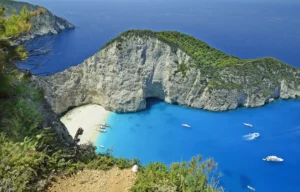 Luxury yacht cruising near Zakynthos with vibrant Ionian Sea waters, dramatic cliffs, and lush island scenery with hints of Corfu in the distance.