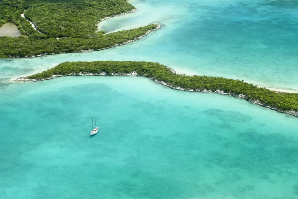 Luxury yacht cruising near the Abaco Islands in the Bahamas, with pristine turquoise waters, lush island scenery, and scenic coastal views.