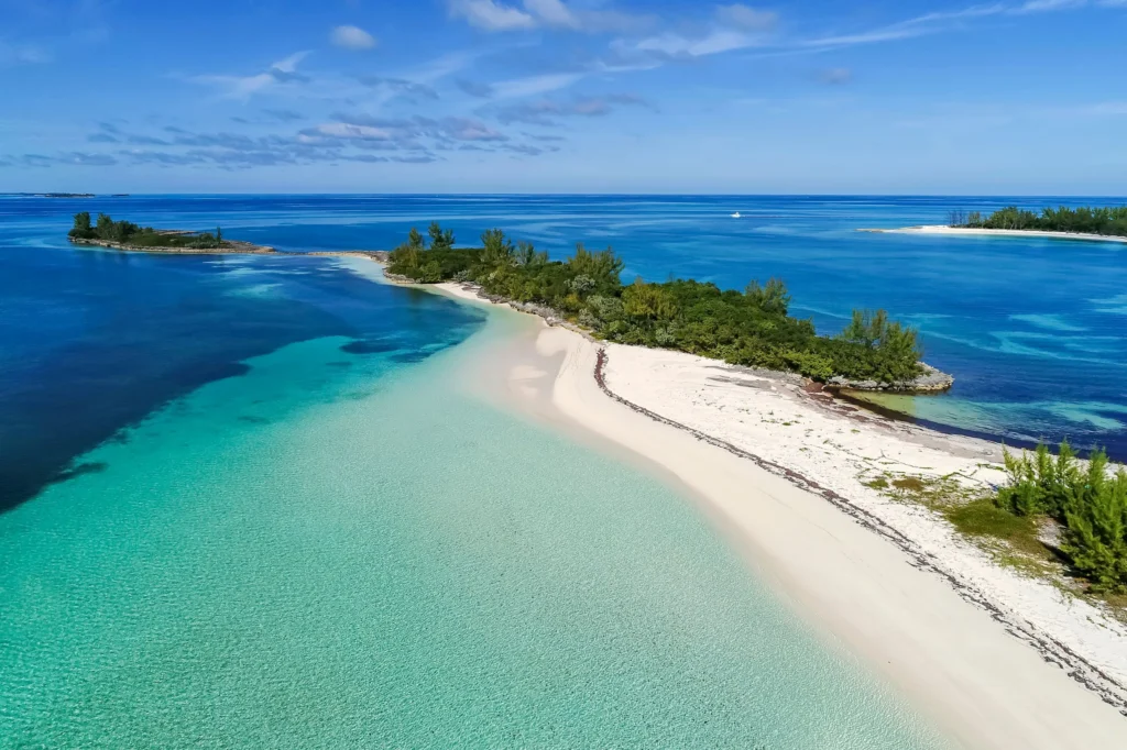 Luxury yacht cruising near the Abaco Islands in the Bahamas, with pristine turquoise waters, lush island scenery, and scenic coastal views.