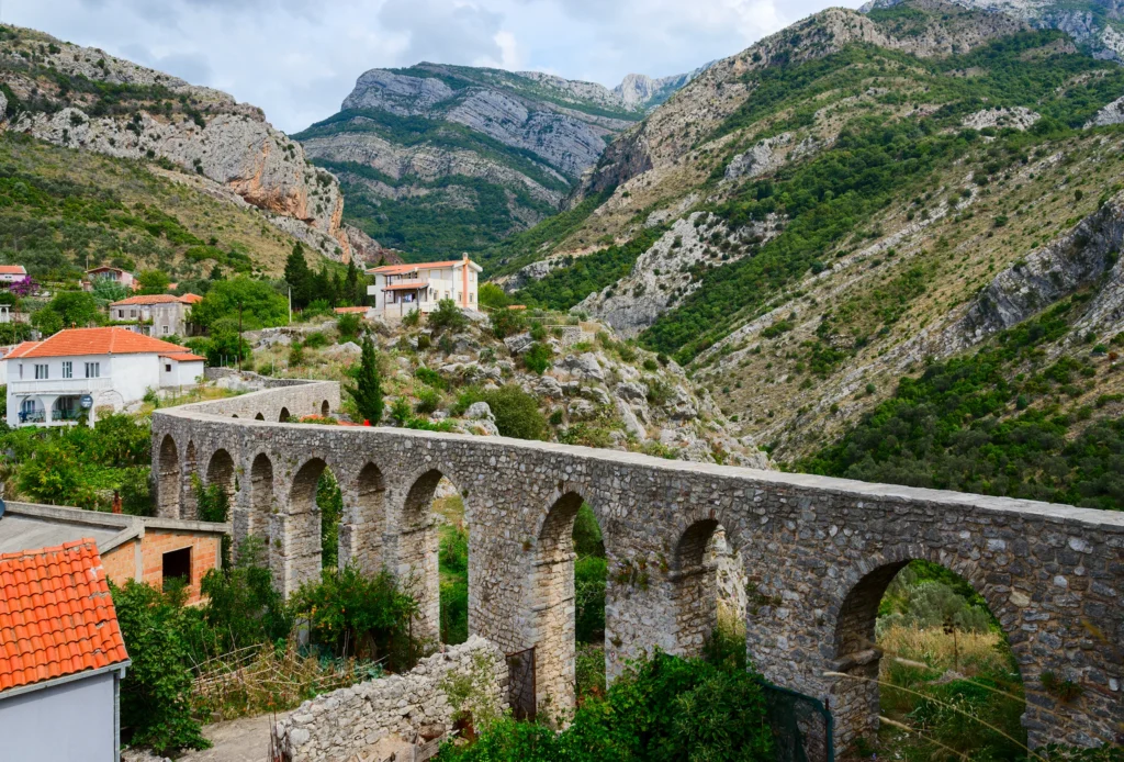 Luxury yacht cruising near Bar, Montenegro, with crystal-clear Adriatic waters, historic coastal views, and a charming marina.