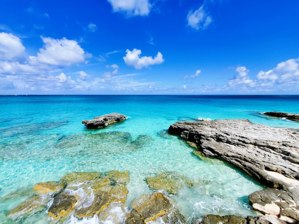 Luxury yacht cruising near Bimini in the Bahamas, with sparkling turquoise waters, pristine sandy beaches, and a vibrant tropical backdrop.
