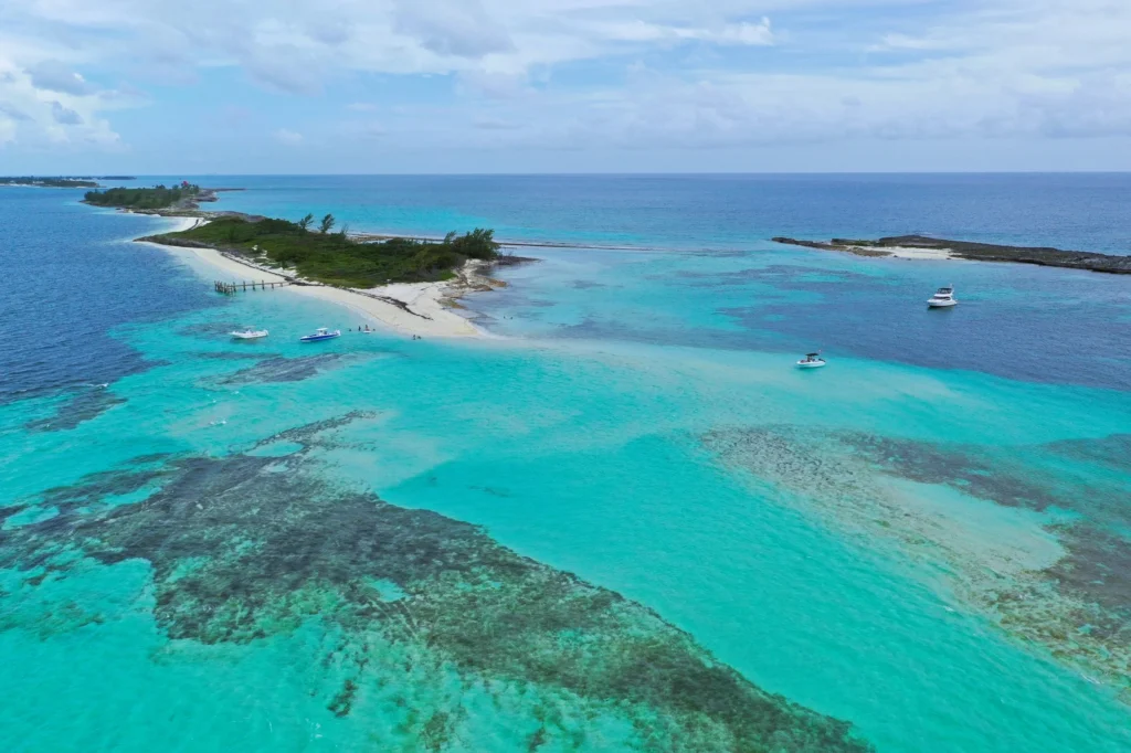 Luxury yacht cruising near Bimini in the Bahamas, with sparkling turquoise waters, pristine sandy beaches, and a vibrant tropical backdrop.