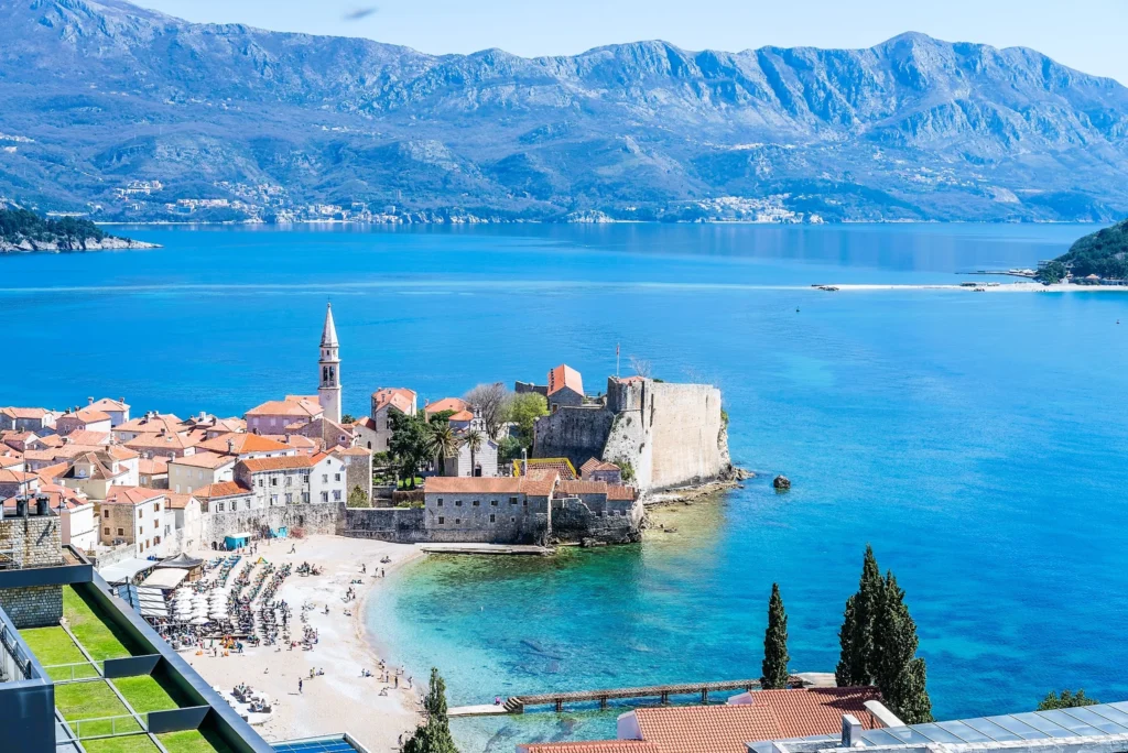 Luxury yacht cruising near Budva, Montenegro, with sparkling Adriatic waters, historic coastal charm, and vibrant marinas.