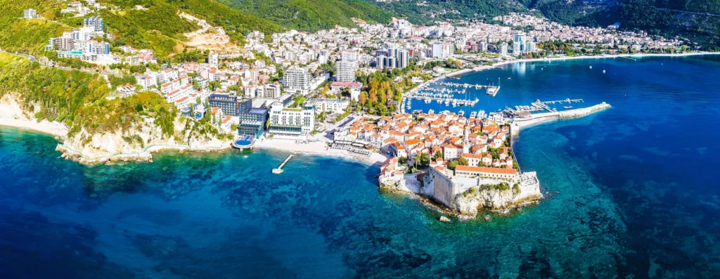 Luxury yacht cruising near Budva, Montenegro, with sparkling Adriatic waters, historic coastal charm, and vibrant marinas.