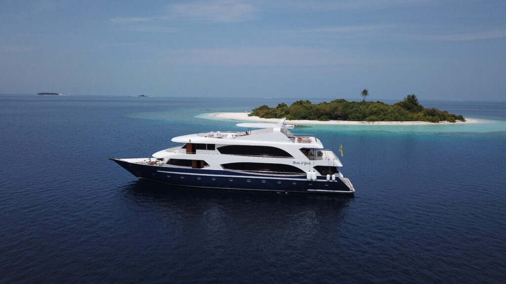 Charter yacht Duke of York cruising through the Maldives with guests relaxing on deck