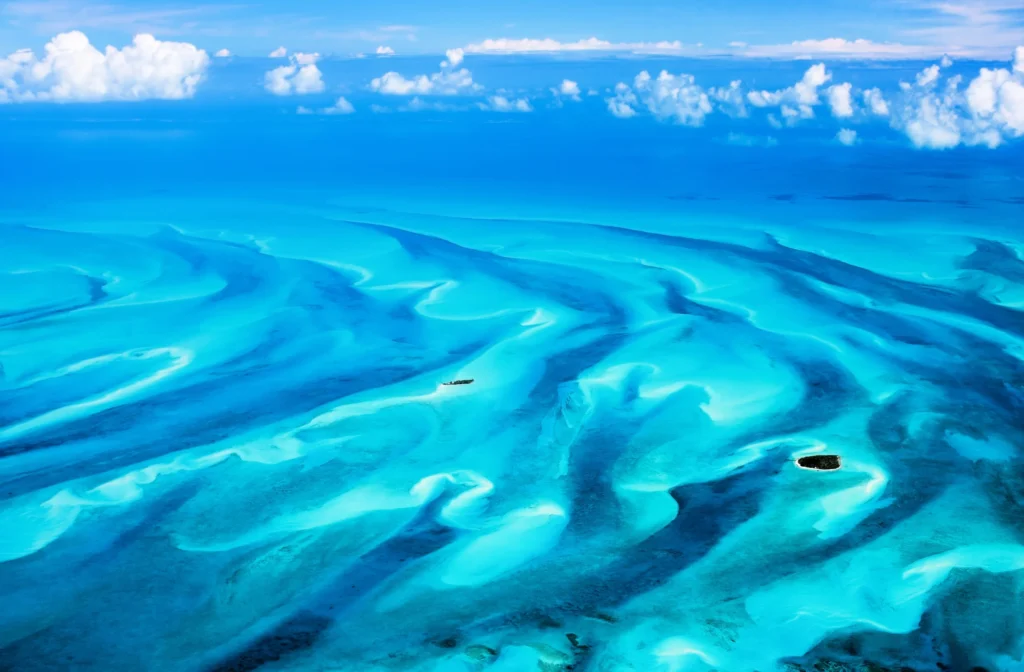 Luxury yacht cruising near Eleuthera in the Bahamas, with crystal-clear waters, pristine beaches, and lush tropical scenery.