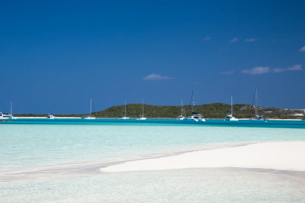Luxury yacht cruising near Exuma Cays in the Bahamas, with sparkling turquoise waters, scattered idyllic islands, and breathtaking Caribbean views.