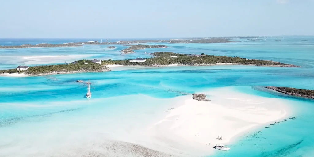Luxury yacht cruising near Exuma Cays in the Bahamas, with sparkling turquoise waters, scattered idyllic islands, and breathtaking Caribbean views.