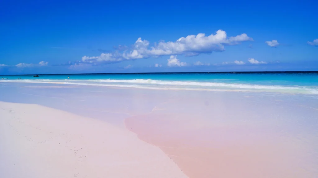 Luxury yacht cruising near Harbour Island, Bahamas, with sparkling turquoise waters, iconic pink sand beaches, and lush tropical scenery.